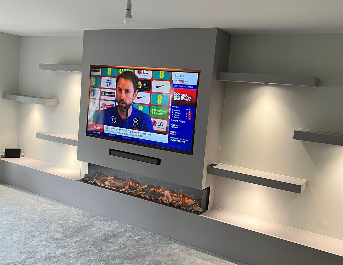 Bespoke media wall with linear inset fire and LED-lit floating shelves by North West Media Walls